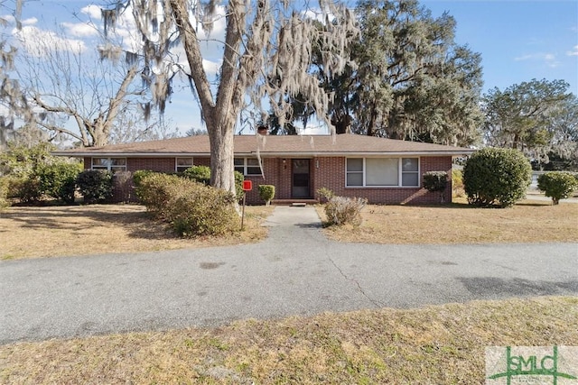 single story home featuring brick siding and driveway