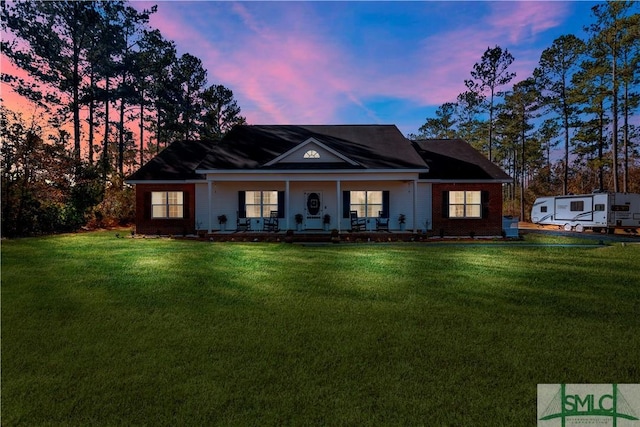 view of front facade featuring covered porch and a lawn