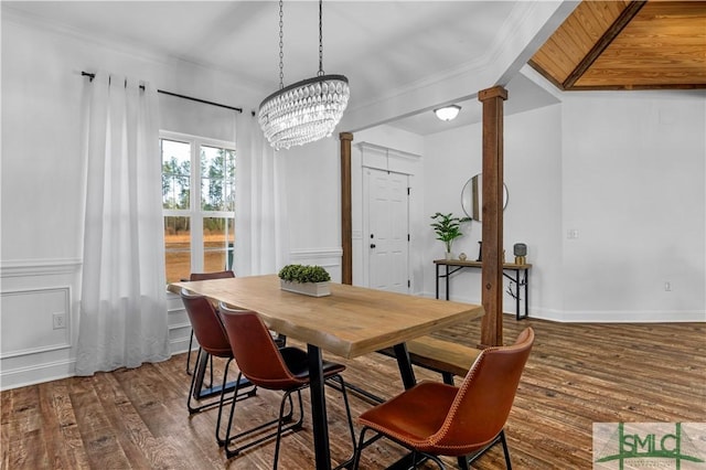 dining area with a notable chandelier, dark wood-type flooring, ornamental molding, and ornate columns