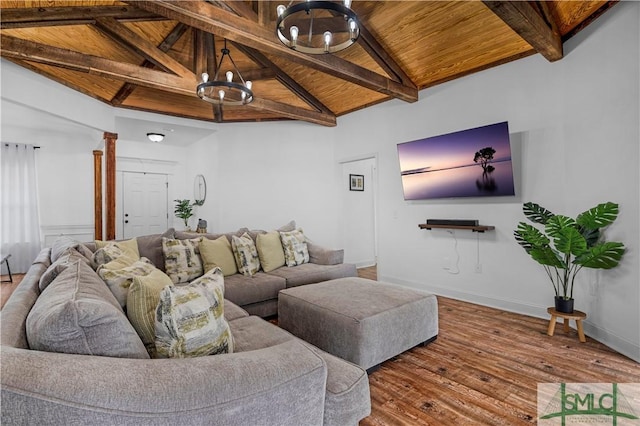 living room featuring ornate columns, hardwood / wood-style floors, a chandelier, wooden ceiling, and beam ceiling