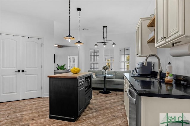 kitchen with a kitchen island, pendant lighting, dishwasher, wood-type flooring, and sink