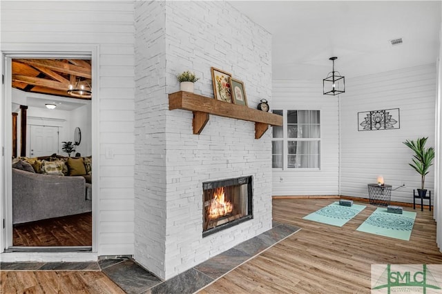 living room with wood-type flooring and a stone fireplace