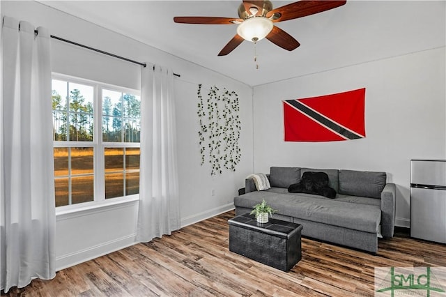 living room featuring wood-type flooring and ceiling fan