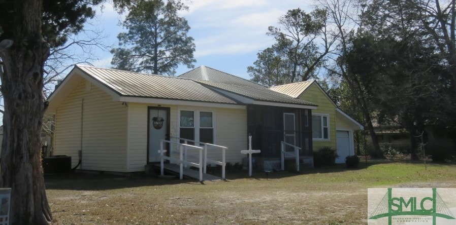 view of front of property with cooling unit and a garage