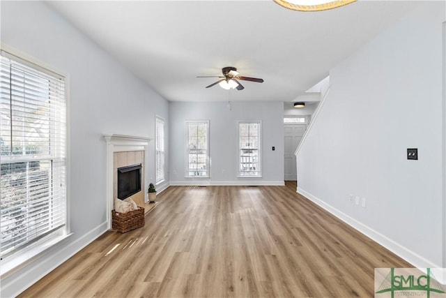 unfurnished living room with a fireplace, light hardwood / wood-style floors, and ceiling fan