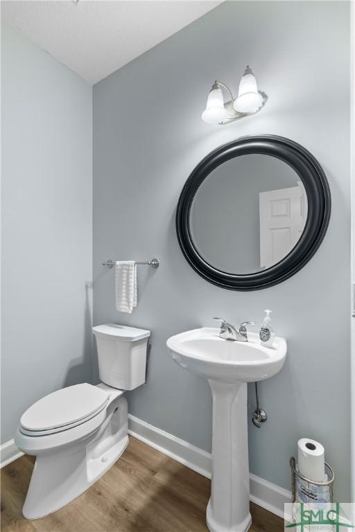 bathroom featuring wood-type flooring and toilet