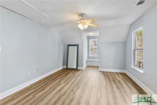 bonus room with plenty of natural light, a textured ceiling, and light hardwood / wood-style flooring