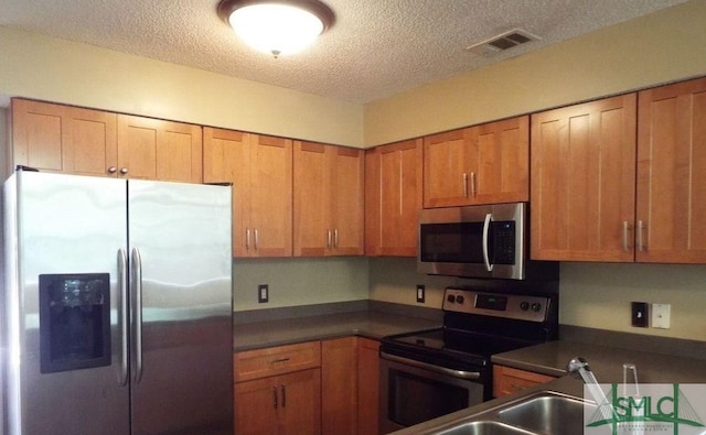 kitchen featuring appliances with stainless steel finishes and a textured ceiling