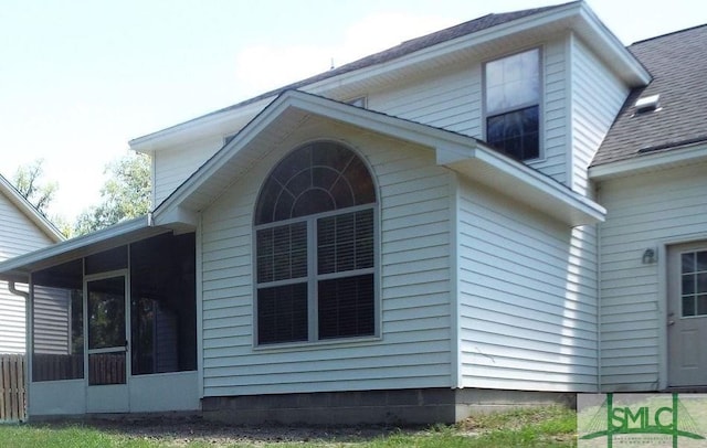 view of property exterior with a sunroom