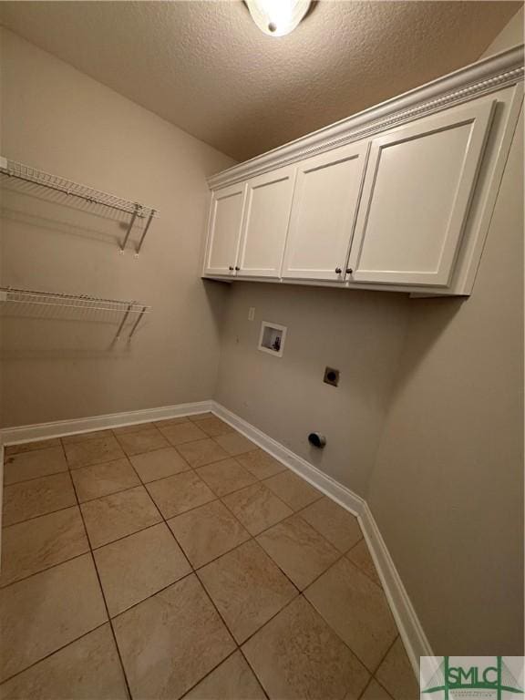 709 Eden Ln, Hinesville, GA 31313 - laundry room with light tile patterned flooring, hookup for an electric dryer, washer hookup, baseboards, and cabinet space