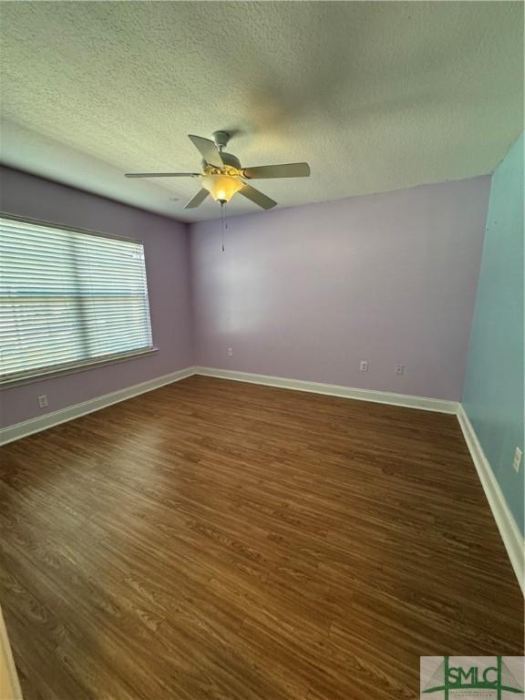 709 Eden Ln, Hinesville, GA 31313 - unfurnished room featuring a textured ceiling, dark wood-type flooring, a ceiling fan, and baseboards