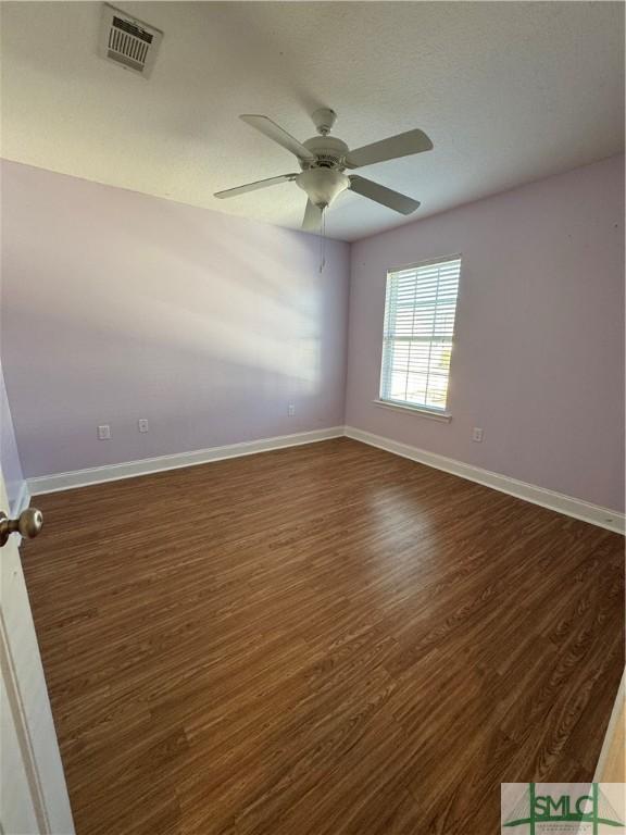 709 Eden Ln, Hinesville, GA 31313 - unfurnished room featuring dark wood-style floors, ceiling fan, visible vents, and baseboards