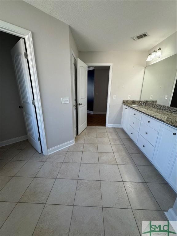 709 Eden Ln, Hinesville, GA 31313 - bathroom with visible vents, baseboards, tile patterned flooring, a textured ceiling, and vanity