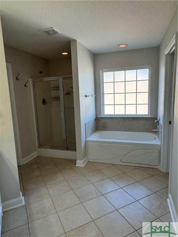 709 Eden Ln, Hinesville, GA 31313 - full bathroom featuring visible vents, tile patterned floors, a textured ceiling, a shower stall, and a bath