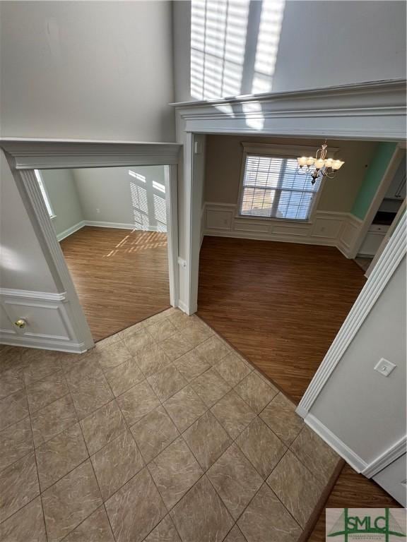 709 Eden Ln, Hinesville, GA 31313 - foyer with a chandelier, a decorative wall, wood finished floors, and wainscoting