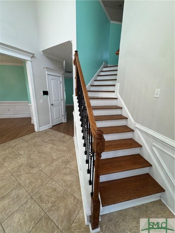 709 Eden Ln, Hinesville, GA 31313 - staircase with ornamental molding, a decorative wall, and wainscoting