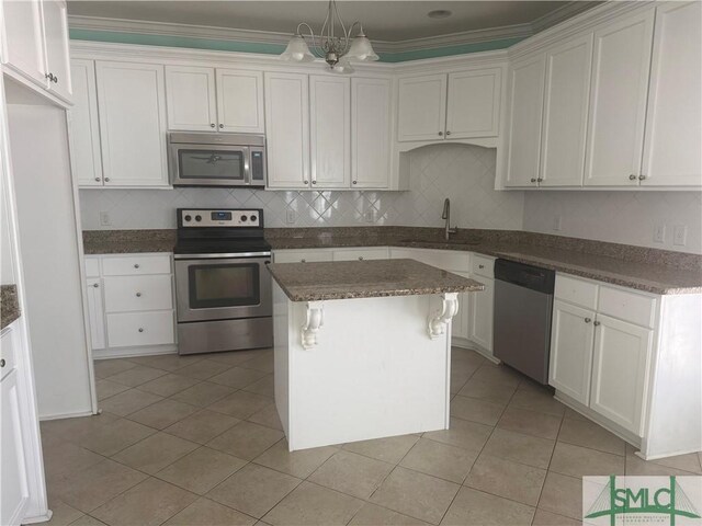 709 Eden Ln, Hinesville, GA 31313 - kitchen featuring stainless steel appliances, tasteful backsplash, light tile patterned flooring, white cabinets, and a kitchen island
