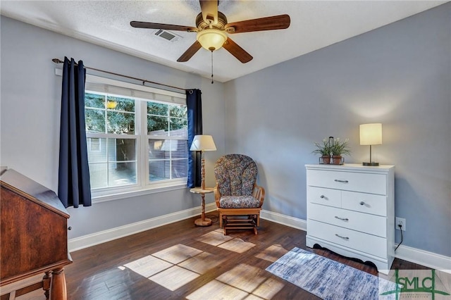 sitting room featuring dark wood-type flooring, ceiling fan, and a textured ceiling