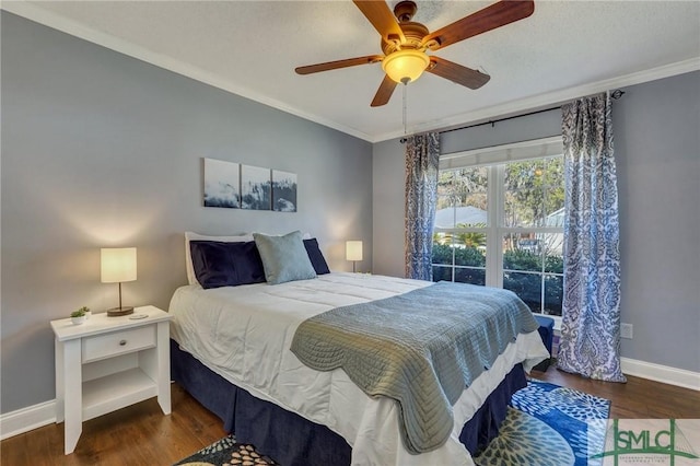 bedroom featuring dark wood-type flooring, ceiling fan, and ornamental molding