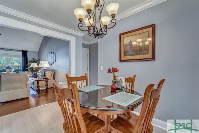 dining room with hardwood / wood-style flooring, crown molding, and an inviting chandelier