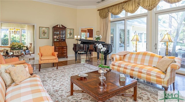 living room featuring ornamental molding, hardwood / wood-style floors, and an inviting chandelier