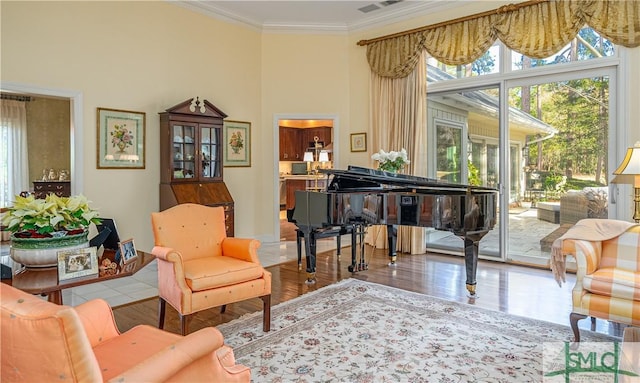 sitting room with crown molding and wood-type flooring