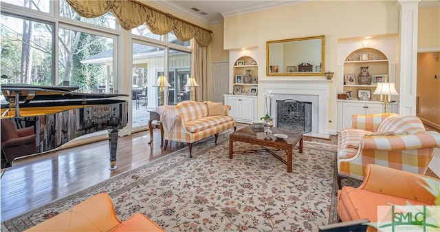 living room with ornamental molding, wood-type flooring, and built in features