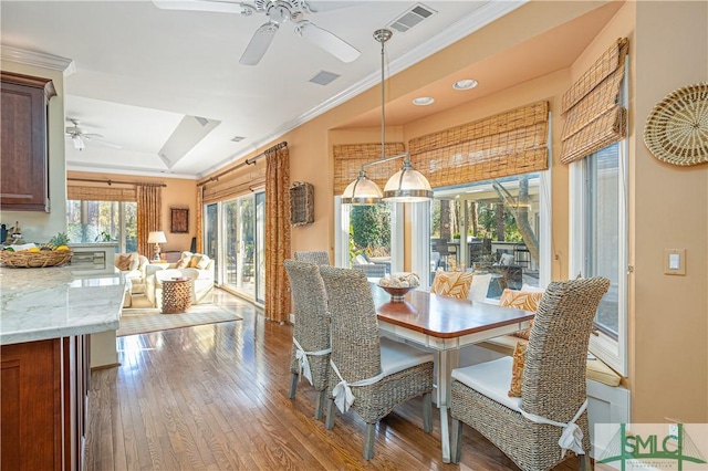 dining area featuring a raised ceiling, crown molding, hardwood / wood-style floors, and ceiling fan