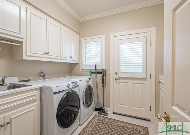 washroom with light tile patterned flooring, sink, crown molding, cabinets, and washer and clothes dryer