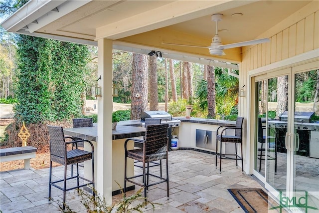 view of patio featuring grilling area, an outdoor bar, and ceiling fan