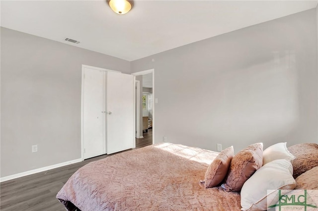 bedroom with dark wood-type flooring and a closet