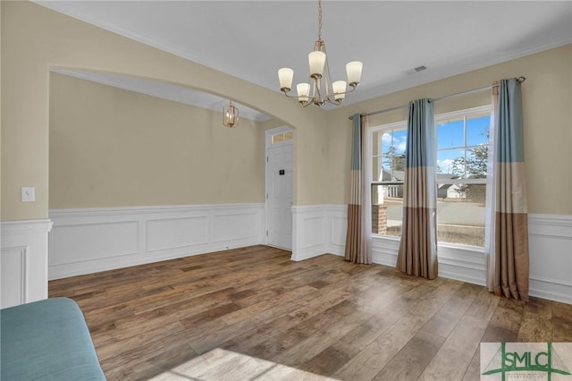 unfurnished dining area with hardwood / wood-style floors and a notable chandelier