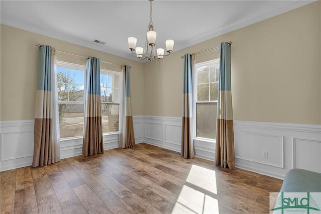 unfurnished dining area with a chandelier and light hardwood / wood-style flooring