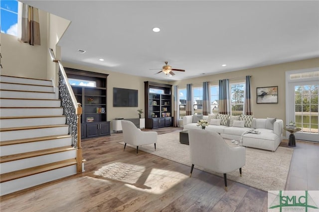 living room with light hardwood / wood-style flooring and ceiling fan