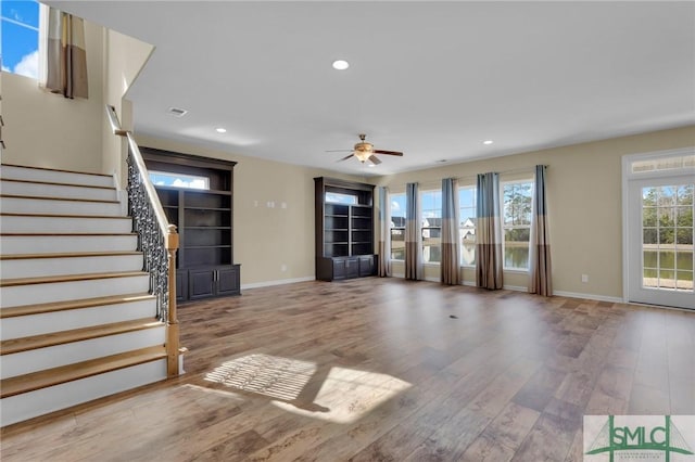 unfurnished living room with wood-type flooring and ceiling fan