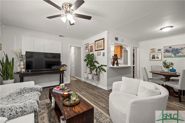 living room featuring hardwood / wood-style flooring, ornamental molding, and ceiling fan