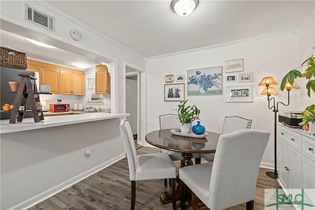 dining area featuring crown molding and dark hardwood / wood-style flooring