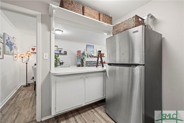 kitchen featuring white cabinetry, stainless steel fridge, and light hardwood / wood-style floors