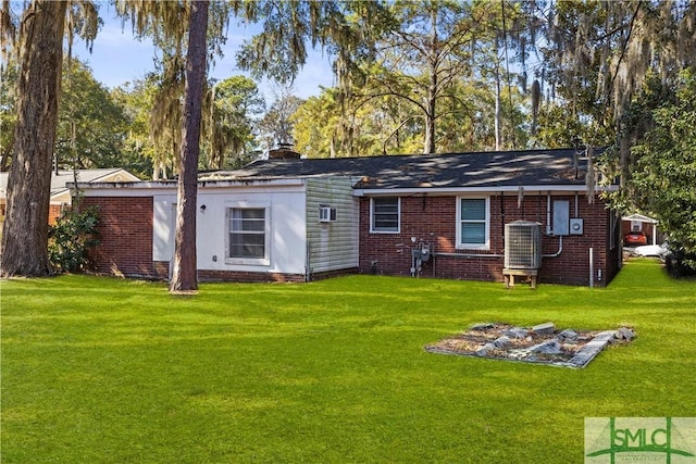 back of property featuring central AC unit and a lawn