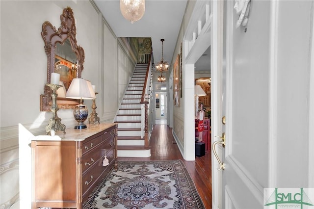 foyer with dark hardwood / wood-style floors and a notable chandelier