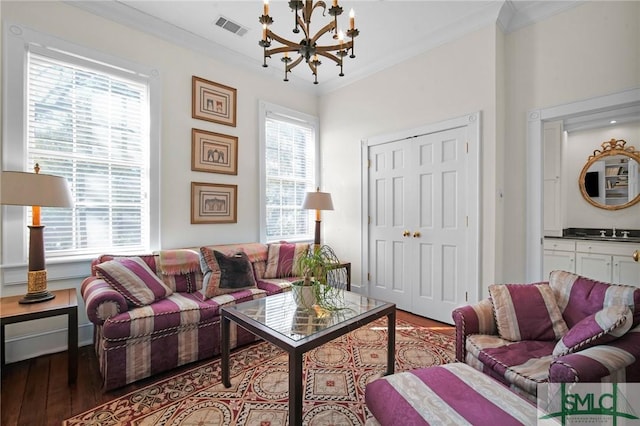 living room featuring an inviting chandelier, sink, crown molding, and a healthy amount of sunlight