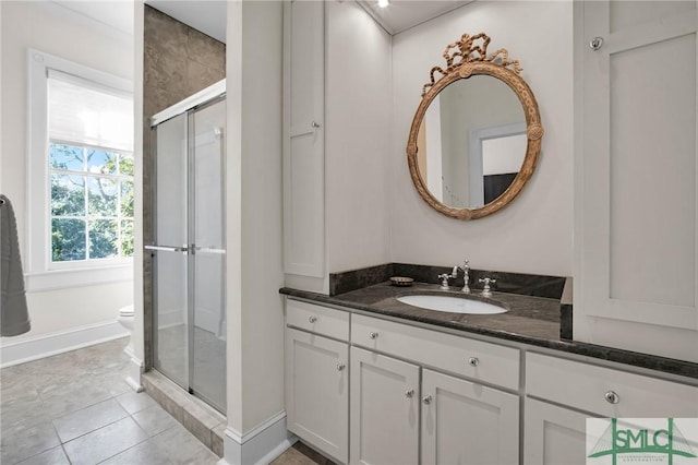 bathroom with vanity, tile patterned floors, toilet, and walk in shower