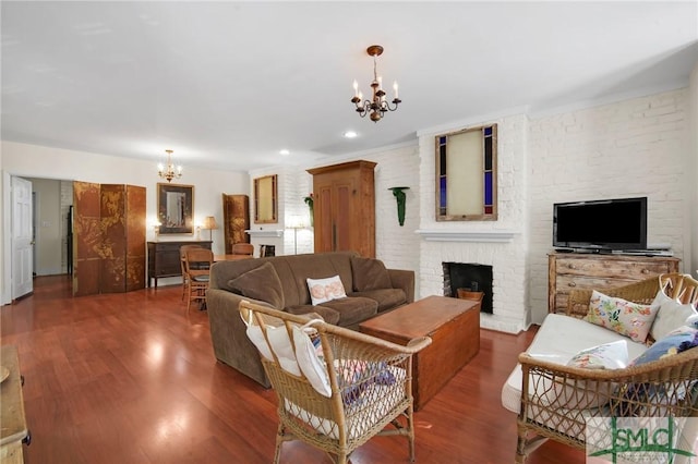 living room featuring dark wood-type flooring, a fireplace, and a notable chandelier