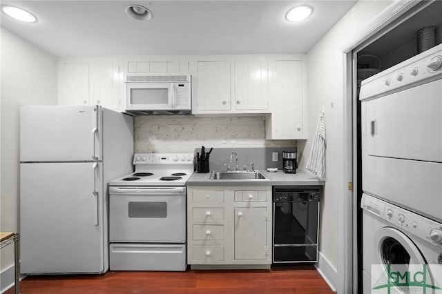 kitchen with sink, white cabinetry, dark hardwood / wood-style flooring, white appliances, and stacked washing maching and dryer