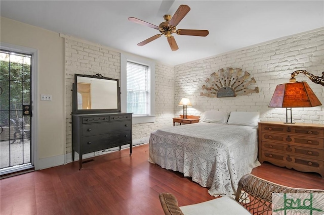 bedroom featuring brick wall, dark wood-type flooring, and ceiling fan