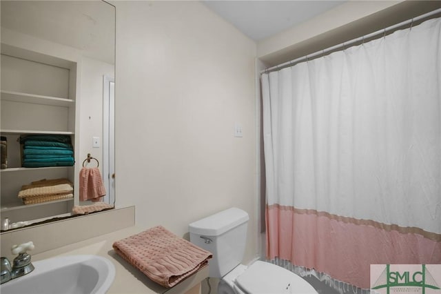 bathroom with sink, toilet, and a shower with shower curtain