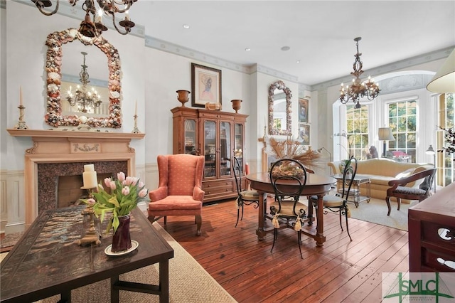 living area featuring a high end fireplace, wood-type flooring, and a notable chandelier