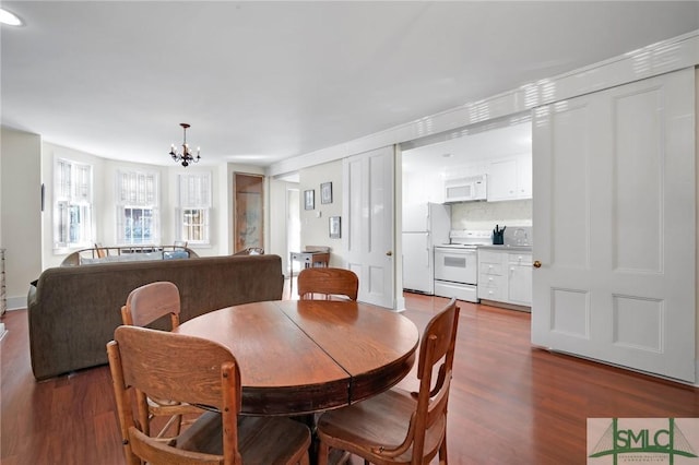 dining space with dark wood-type flooring and a notable chandelier