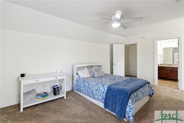 carpeted bedroom with vaulted ceiling, ceiling fan, and ensuite bath