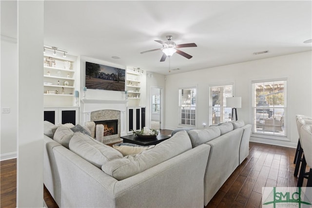 living room featuring ceiling fan, dark hardwood / wood-style flooring, and built in features